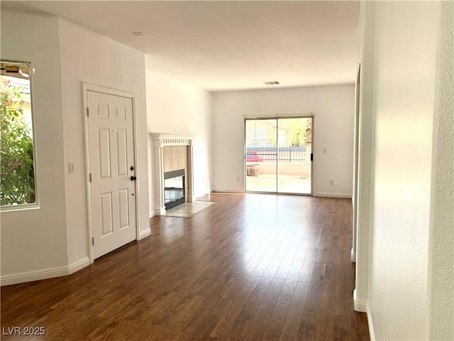 9236 Canalino Dr, Las Vegas, NV 89134 - unfurnished living room with dark wood finished floors, a tile fireplace, and baseboards