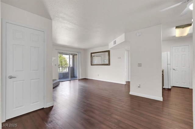 unfurnished living room featuring dark wood-style floors, a ceiling fan, and baseboards