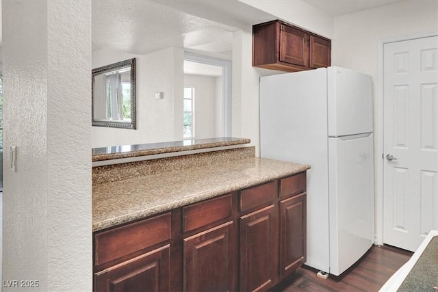 kitchen featuring freestanding refrigerator and dark wood-type flooring