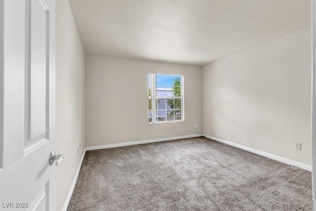 unfurnished room with carpet and baseboards