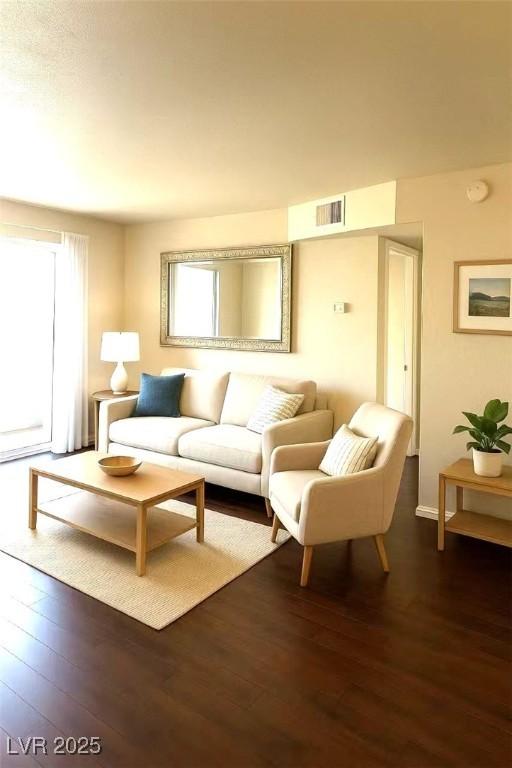 living area featuring dark wood-style flooring, plenty of natural light, and baseboards