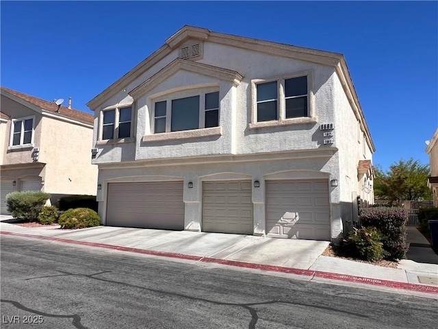 8688 Tomnitz Ave Unit 101, Las Vegas, NV 89178 - view of property featuring an attached garage, stucco siding, and concrete driveway
