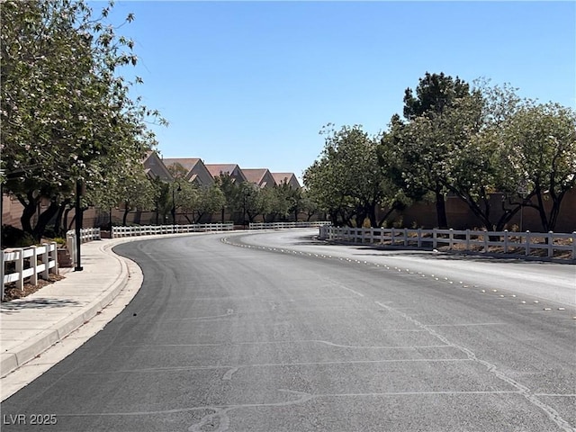 8688 Tomnitz Ave Unit 101, Las Vegas, NV 89178 - view of asphalt road with curbs and sidewalks