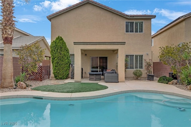 back of house featuring stucco siding, fence, an outdoor pool, and a patio area