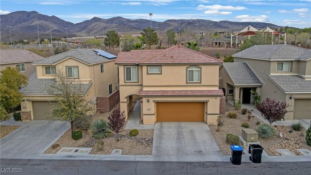 traditional-style home featuring driveway, stucco siding, an attached garage, a residential view, and a mountain view