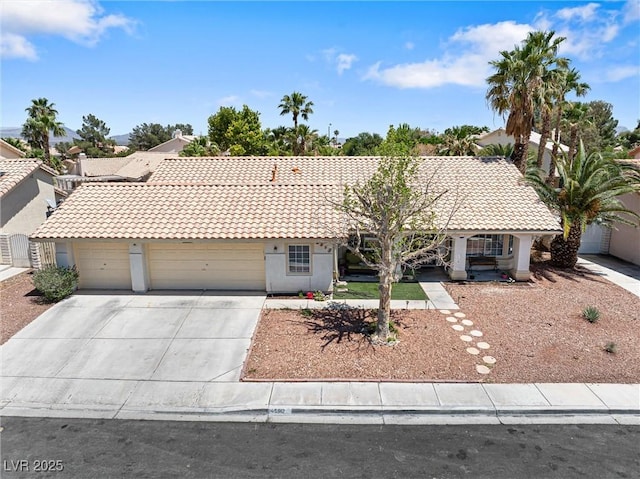5912 Hollowridge Rd, North Las Vegas, NV 89031 - single story home with concrete driveway, a tiled roof, a garage, and stucco siding
