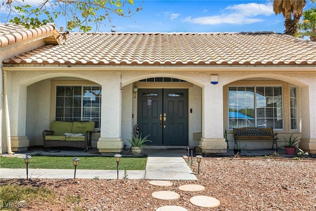 5912 Hollowridge Rd, North Las Vegas, NV 89031 - doorway to property featuring covered porch, stucco siding, and a tile roof