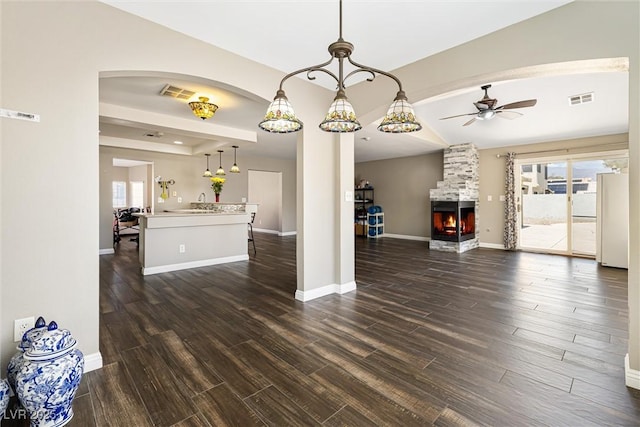 5912 Hollowridge Rd, North Las Vegas, NV 89031 - unfurnished living room with plenty of natural light, dark wood finished floors, ceiling fan, and a stone fireplace