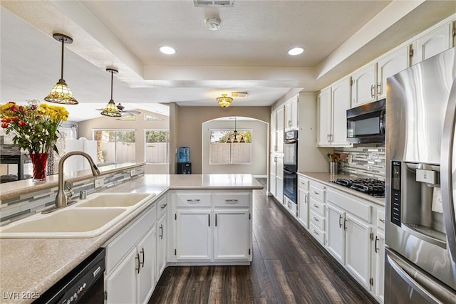 5912 Hollowridge Rd, North Las Vegas, NV 89031 - kitchen with black appliances, a sink, a raised ceiling, dark wood-style flooring, and white cabinetry