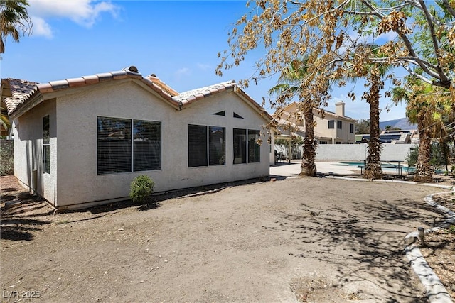 5912 Hollowridge Rd, North Las Vegas, NV 89031 - rear view of house featuring stucco siding, fence, a tile roof, and a patio