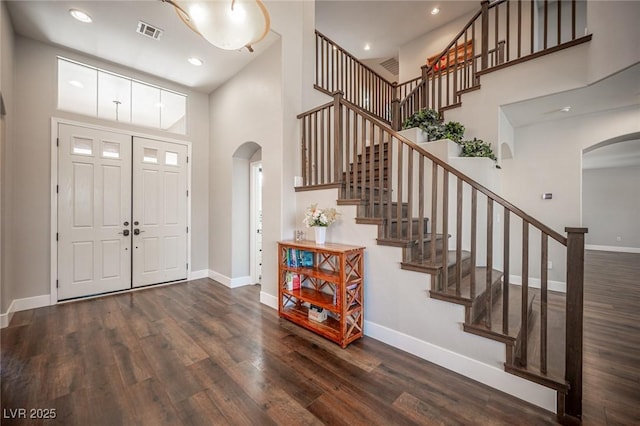 11112 Pine Greens Ct, Las Vegas, NV 89144 - entrance foyer with arched walkways, wood finished floors, baseboards, a high ceiling, and stairs