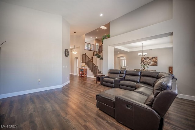 11112 Pine Greens Ct, Las Vegas, NV 89144 - living room with stairs, baseboards, dark wood-style floors, arched walkways, and recessed lighting