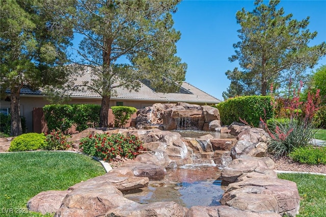 11112 Pine Greens Ct, Las Vegas, NV 89144 - view of side of property with a tile roof, a garden pond, and stucco siding