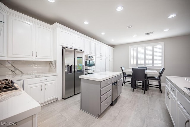 11112 Pine Greens Ct, Las Vegas, NV 89144 - kitchen with appliances with stainless steel finishes, white cabinets, recessed lighting, and light stone counters