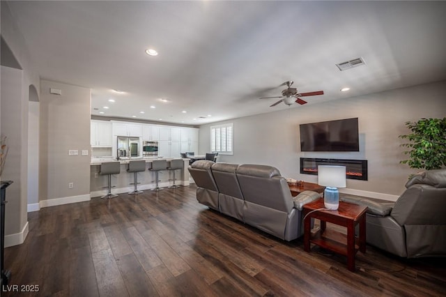11112 Pine Greens Ct, Las Vegas, NV 89144 - living area featuring dark wood-type flooring, a ceiling fan, recessed lighting, baseboards, and a glass covered fireplace