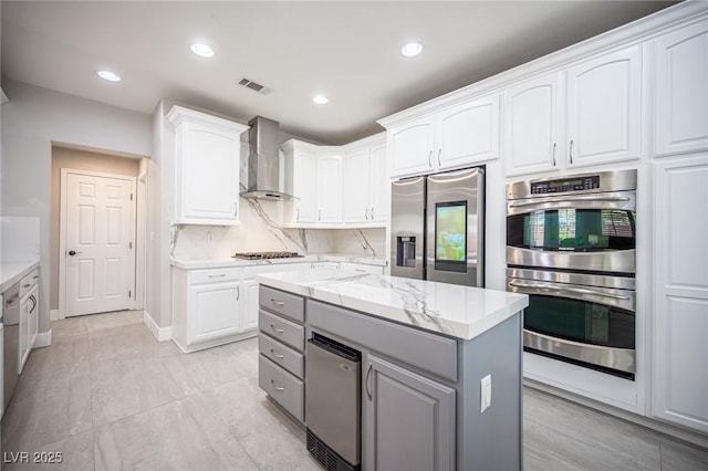11112 Pine Greens Ct, Las Vegas, NV 89144 - kitchen with wall chimney exhaust hood, stainless steel appliances, white cabinets, gray cabinetry, and recessed lighting