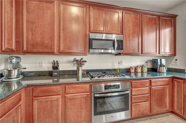 11908 Menchaca Ln, Las Vegas, NV 89138 - kitchen featuring stainless steel appliances, dark stone countertops, and brown cabinets