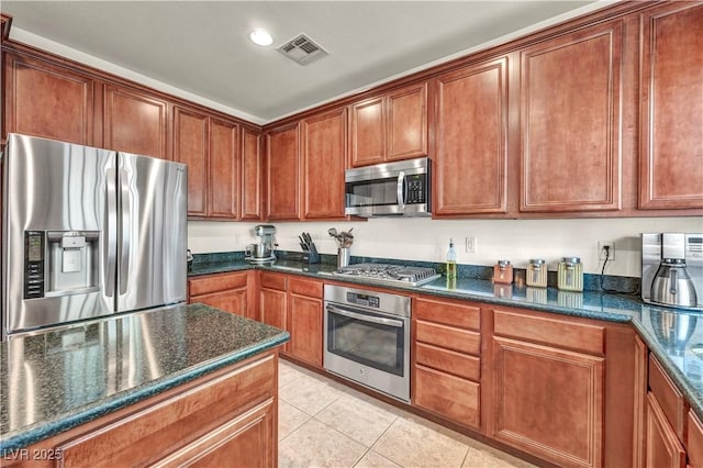 11908 Menchaca Ln, Las Vegas, NV 89138 - kitchen with stainless steel appliances, light tile patterned flooring, dark stone countertops, and recessed lighting