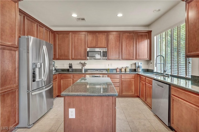 11908 Menchaca Ln, Las Vegas, NV 89138 - kitchen featuring stainless steel appliances, a kitchen island, a sink, dark stone counters, and light tile patterned floors