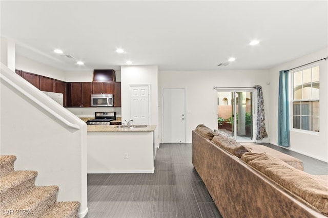 4533 Lime Straight Dr, Las Vegas, NV 89115 - kitchen featuring stainless steel appliances, open floor plan, recessed lighting, dark brown cabinets, and a sink