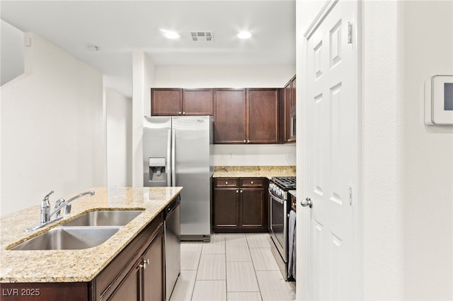 4533 Lime Straight Dr, Las Vegas, NV 89115 - kitchen with a sink, appliances with stainless steel finishes, light stone countertops, dark brown cabinetry, and recessed lighting