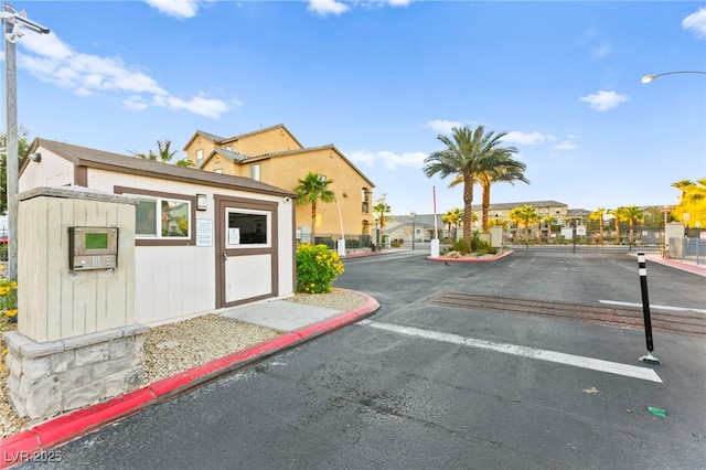 4533 Lime Straight Dr, Las Vegas, NV 89115 - view of asphalt road with street lights, a gate, curbs, a residential view, and a gated entry