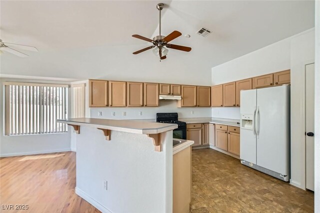 3912 Branchwood Dr, North Las Vegas, NV 89032 - kitchen with white fridge with ice dispenser, black range with gas stovetop, a ceiling fan, under cabinet range hood, and high vaulted ceiling