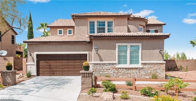 mediterranean / spanish home with fence, stone siding, driveway, and stucco siding