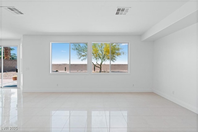 spare room with light tile patterned floors and baseboards
