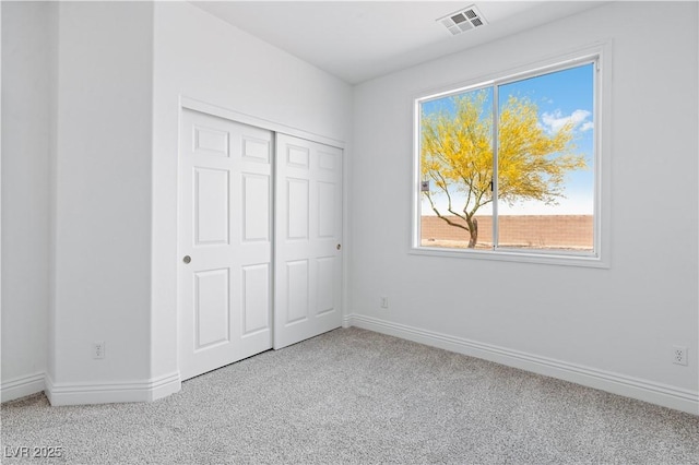 unfurnished bedroom with carpet flooring, baseboards, and a closet