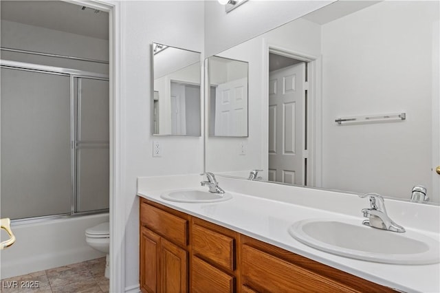full bathroom with toilet, double vanity, and shower / bath combination with glass door