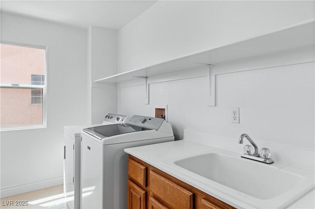 clothes washing area featuring a sink, separate washer and dryer, and light tile patterned floors