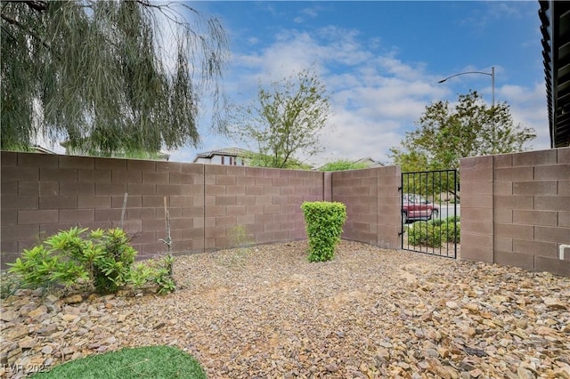 view of yard with fence and a gate