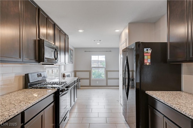 kitchen featuring black appliances, dark brown cabinetry, backsplash, light stone countertops, and recessed lighting
