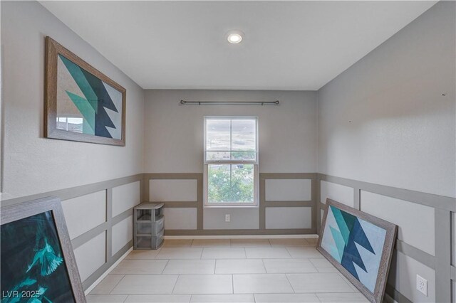 unfurnished room with wainscoting, a decorative wall, and recessed lighting