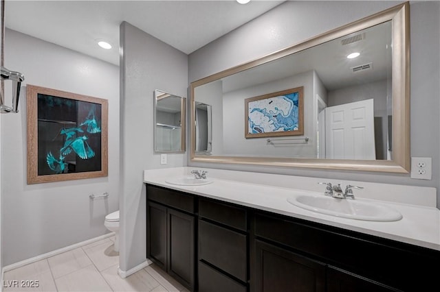 full bathroom with toilet, double vanity, baseboards, and tile patterned flooring