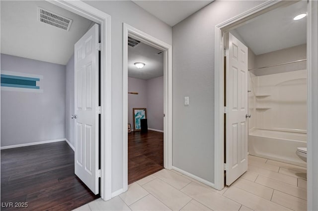 corridor featuring baseboards and light wood-style floors