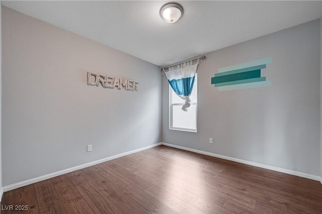 spare room with wood finished floors and baseboards