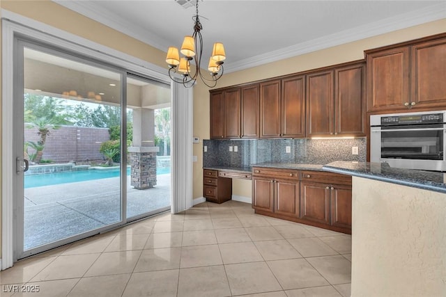 7505 Java Sparrow St, North Las Vegas, NV 89084 - kitchen with stainless steel oven, decorative backsplash, crown molding, a chandelier, and pendant lighting
