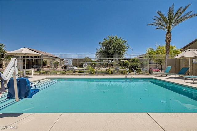 community pool with fence and a patio