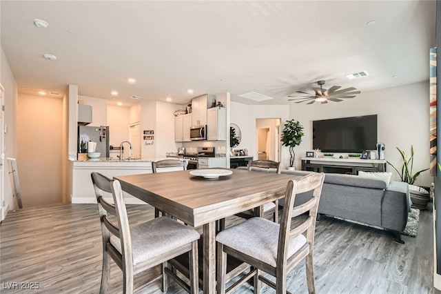 dining room featuring light wood finished floors, ceiling fan, and recessed lighting