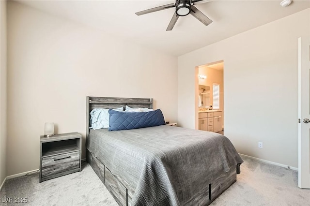 bedroom with light colored carpet, baseboards, and ensuite bath