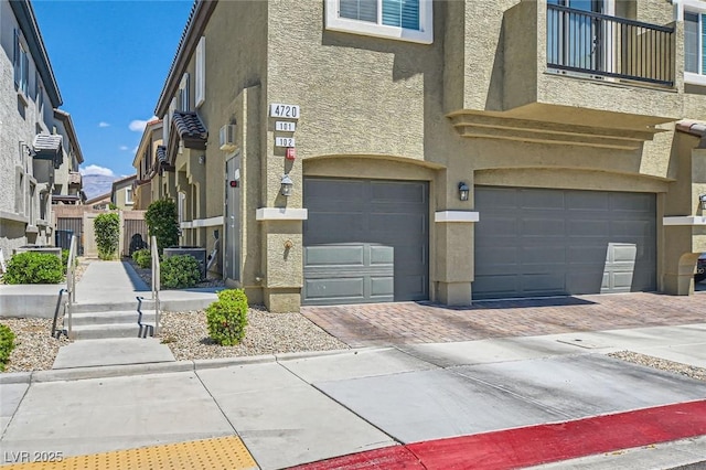 view of property with an attached garage, decorative driveway, and a residential view