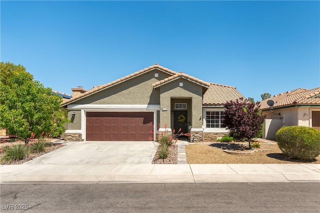 mediterranean / spanish-style house featuring an attached garage, stucco siding, stone siding, driveway, and a tiled roof