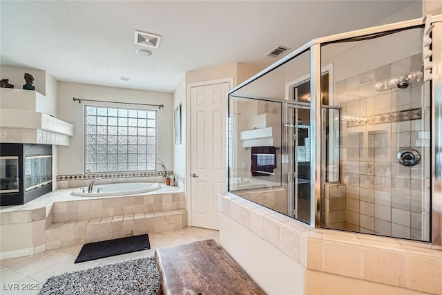 full bath with tile patterned flooring, a bath, and a stall shower