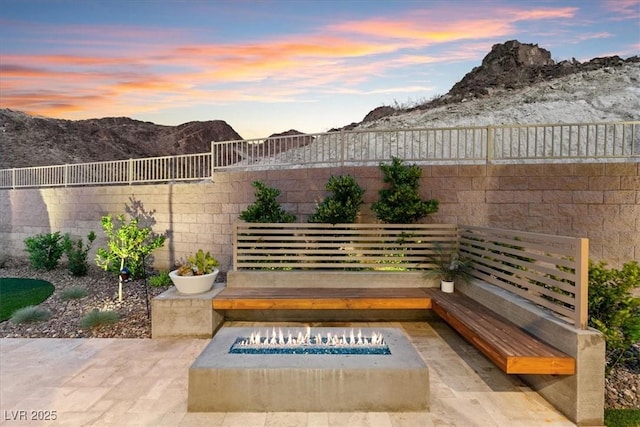 38 Costa Tropical Dr, Henderson, NV 89011 - patio terrace at dusk with a fire pit, a mountain view, and fence