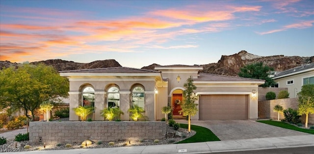38 Costa Tropical Dr, Henderson, NV 89011 - view of front of property featuring a garage, driveway, stucco siding, a mountain view, and fence
