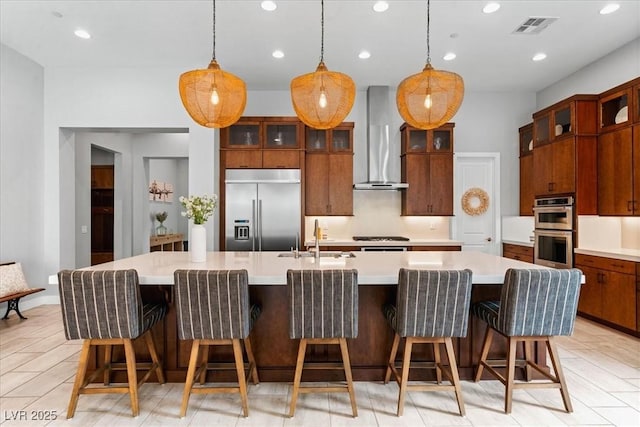 38 Costa Tropical Dr, Henderson, NV 89011 - kitchen featuring appliances with stainless steel finishes, wall chimney exhaust hood, a sink, light countertops, and a large island