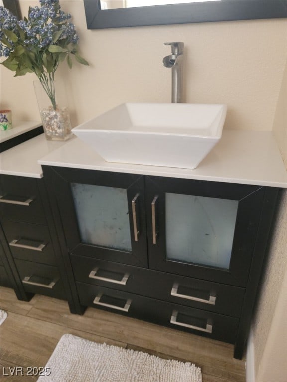 bathroom view of wood finished floors and vanity