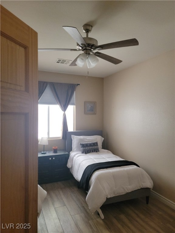 bedroom with light wood-style floors, ceiling fan, and baseboards